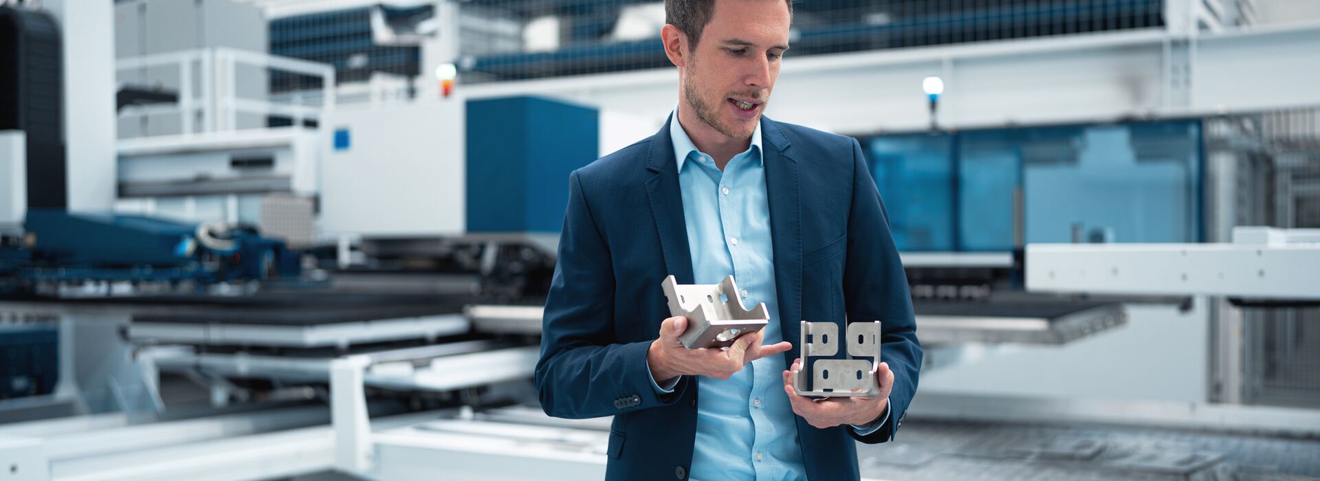Mann hält ein präzise gefertigtes Blechbauteil in der Hand